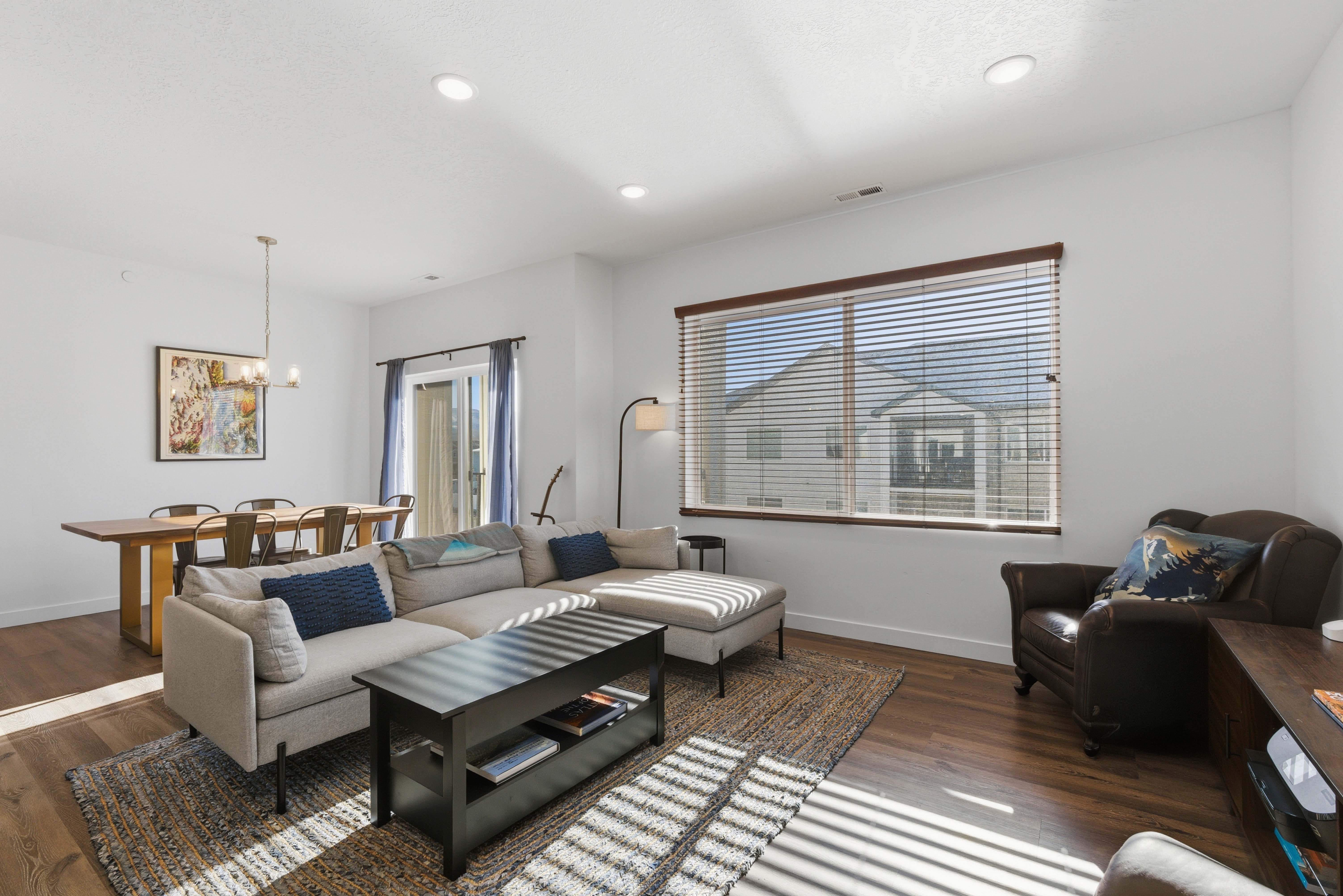 Living room with dark wood-type flooring, a chandelier, and recessed lighting