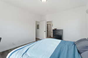 Bedroom featuring wood finished floors and electric panel