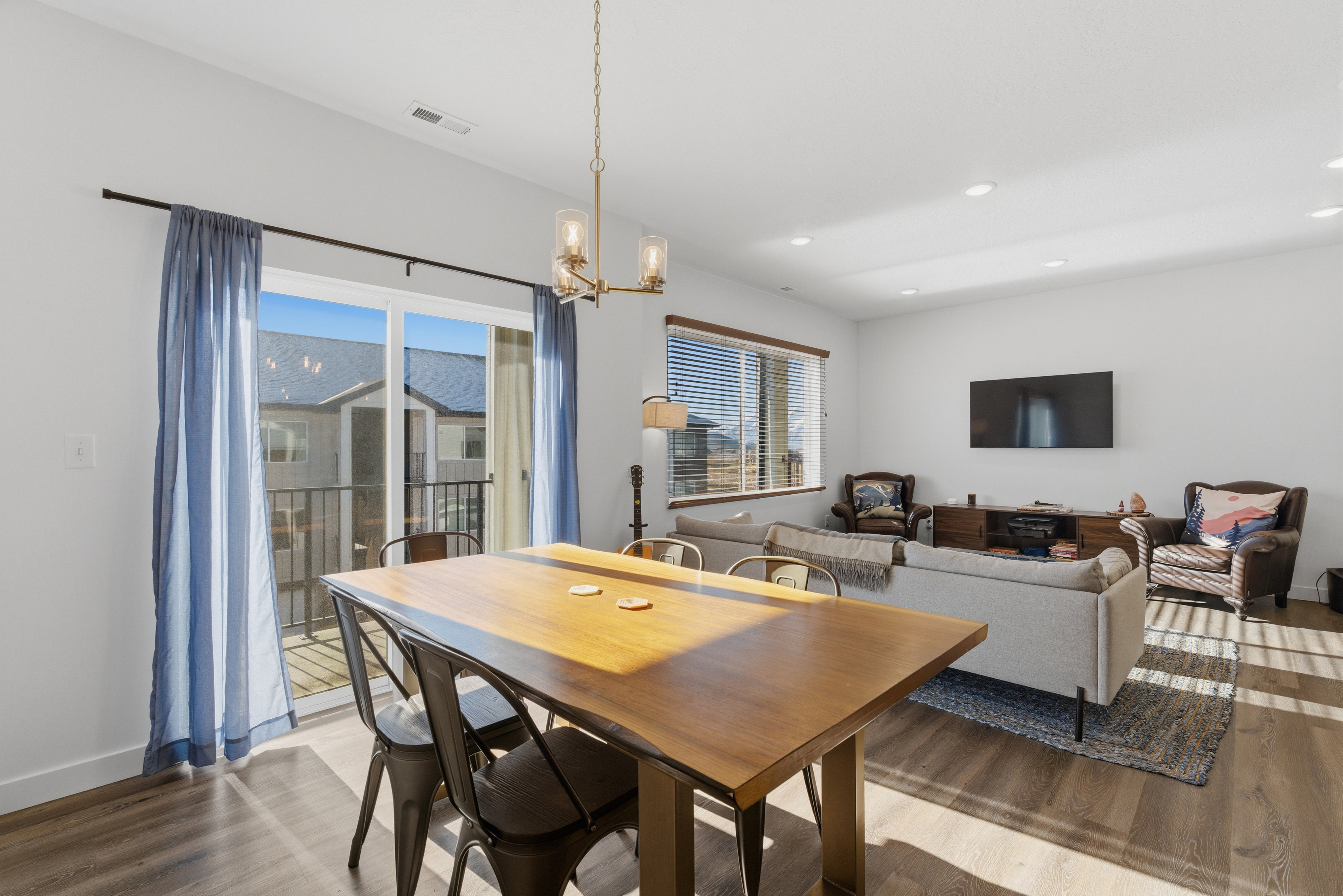 Dining space with wood finished floors, a chandelier, healthy amount of natural light, and recessed lighting