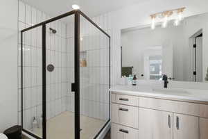 Full bathroom featuring vanity and a shower stall