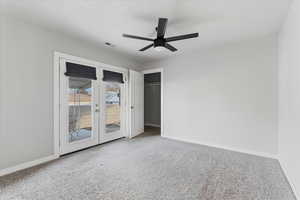 Unfurnished bedroom featuring access to outside, carpet floors, a closet, and ceiling fan