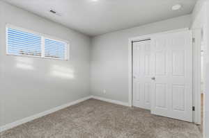 Unfurnished bedroom with carpet flooring and a closet
