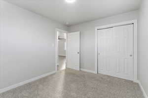 Unfurnished bedroom featuring a closet and baseboards