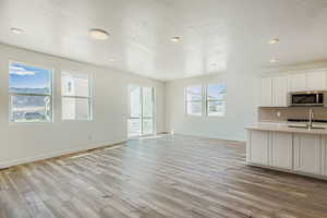 Unfurnished living room featuring a textured ceiling, light wood-style flooring, and recessed lighting