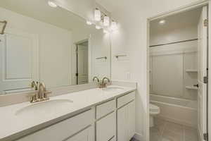 Full bath with double vanity, light tile patterned floors, bathtub / shower combination, and recessed lighting