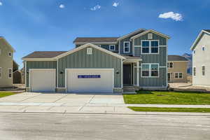 Craftsman-style house with board and batten siding, a front yard, roof with shingles, a garage, and concrete driveway