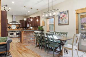 Dining room with light wood-style flooring and recessed lighting