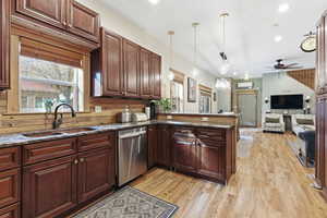 Kitchen with dark stone counters, plenty of natural light, recessed lighting, pendant lighting, and stainless steel dishwasher