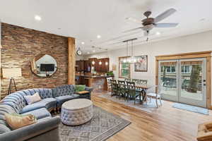 Living room with recessed lighting, a ceiling fan, and light wood finished floors