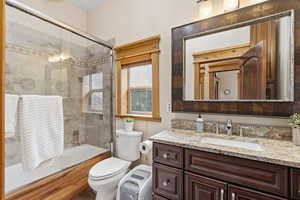 Full bath with shower / bath combination with glass door and vanity