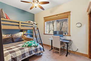 Bedroom featuring carpet, ceiling fan, and an office area