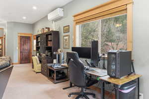 Office space with a wall mounted air conditioner, light colored carpet, and recessed lighting