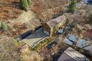 Aerial view of property and surrounding area with a tree filled landscape