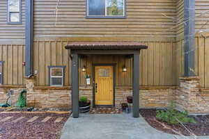 Property entrance featuring board and batten siding and stone siding