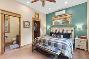 Carpeted bedroom featuring a spacious closet, heating unit, a ceiling fan, a wall mounted AC, and recessed lighting