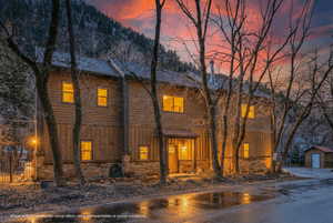 Rustic home with stone siding, board and batten siding, and an outdoor structure