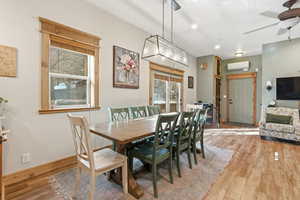 Dining space featuring light wood-type flooring, a ceiling fan, recessed lighting, and a wall mounted AC