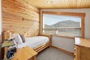 Bedroom with wood walls and wood ceiling