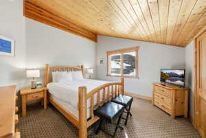 Bedroom featuring wooden ceiling and vaulted ceiling