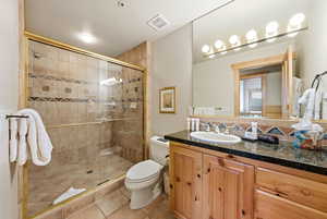 Bathroom with vanity, a stall shower, and light tile patterned floors