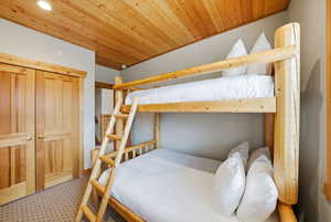 Bedroom with wooden ceiling, a closet, and tile patterned floors