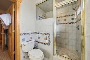 Bathroom featuring tile walls and a shower stall