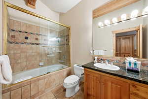 Full bath featuring tiled shower / bath combo, vanity, and tile patterned floors