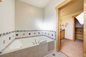 Full bathroom featuring a bath, vanity, and tile patterned flooring