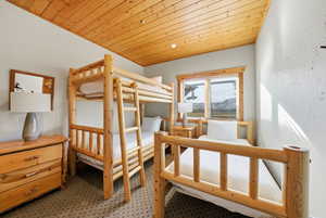 Bedroom featuring wood ceiling and light carpet