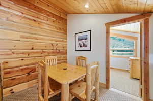 Dining area with wood walls, vaulted ceiling, and wood ceiling