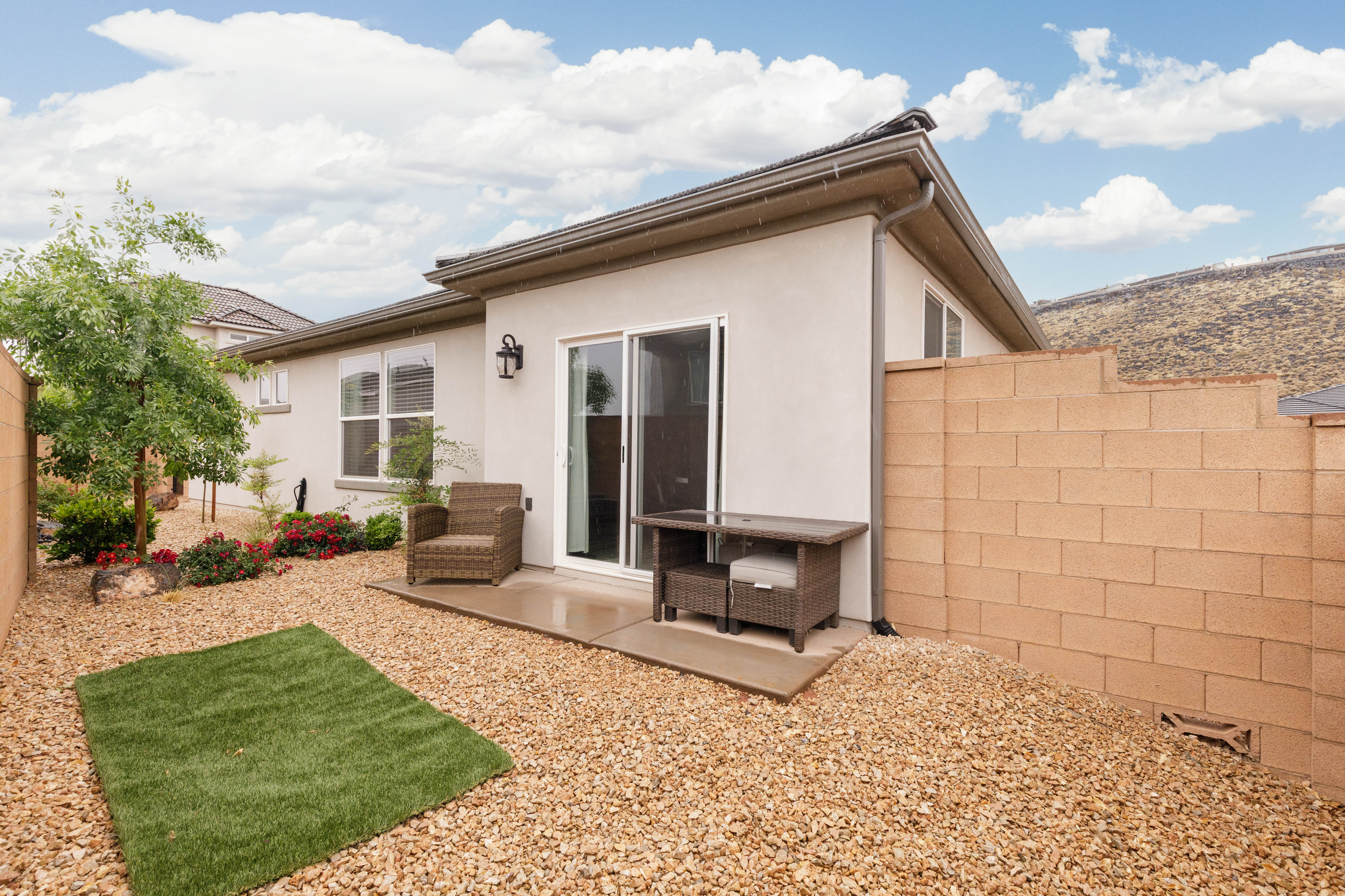 Back of property with stucco siding and a patio