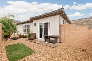 Back of property with stucco siding and a patio