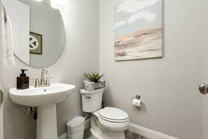 Half bathroom with baseboards and toilet