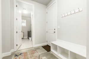 Mudroom featuring light wood finished floors and baseboards