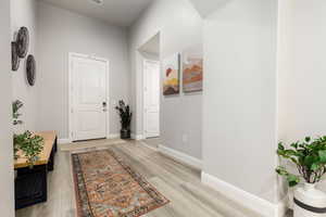 Corridor with baseboards and light wood-style flooring