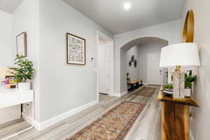 Entry way featuring arched walkways and light wood finished floors