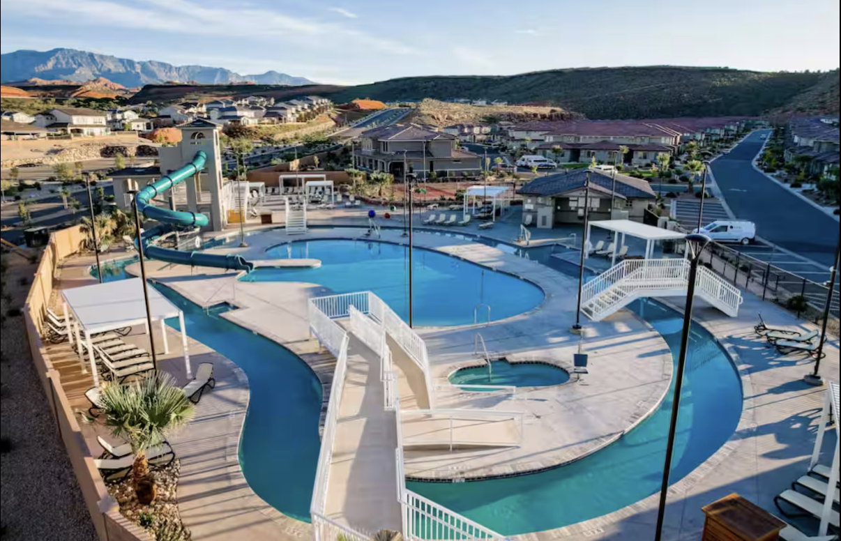 Community pool with a community hot tub, a water slide, lazy river, a mountain view, and a residential view