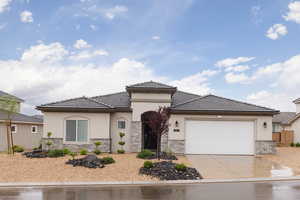 View of front of property featuring stone siding, stucco siding, concrete driveway, and an attached garage