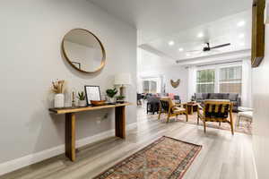 Entryway with recessed lighting, a raised ceiling, light wood-style floors, and ceiling fan