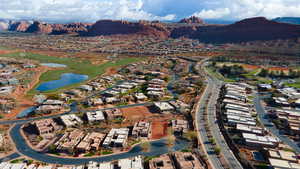 Aerial view of property's location with a water and mountain view, nearby suburban area, and a local golf course