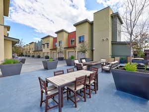 View of patio with an outdoor living space with a fire pit, outdoor dining space, and a residential view