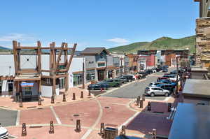 View of asphalt road with a mountain view, street lights, sidewalks, and curbs