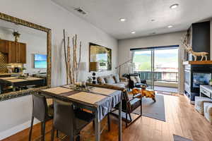 Dining space with light wood-style flooring, a textured ceiling, and recessed lighting