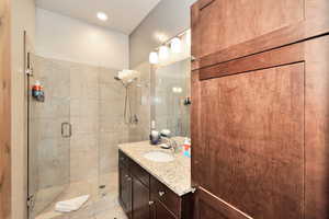 Full bathroom with vanity, a shower stall, and recessed lighting