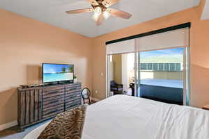 Carpeted bedroom featuring a ceiling fan and access to outside