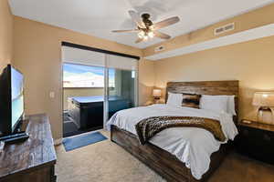Carpeted bedroom with access to exterior and a ceiling fan