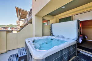 View of patio / terrace featuring a hot tub and a mountain view