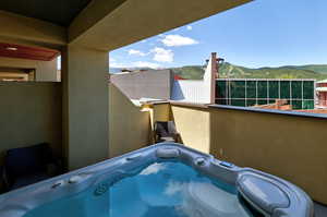 Exterior view of stucco siding, a mountainous background, and a jacuzzi