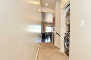 Washroom featuring light carpet, recessed lighting, and estacked washer and dryer