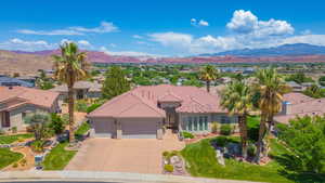 View of front of home with a garage, stucco siding, a mountain view, and concrete driveway